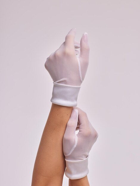 Female hands in transparent black gloves on dress background Retro style