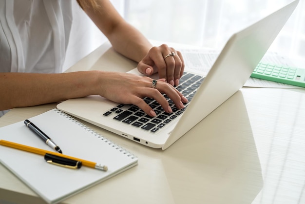 Female hands typing on laptop keyboard close up