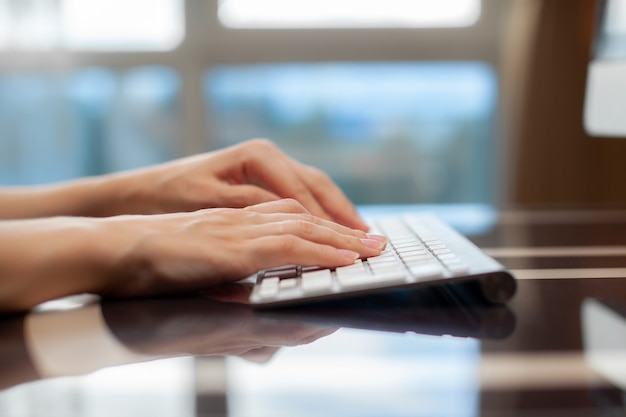 Female hands typing text on the keyboard while exchanging messages