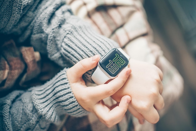 Female hands using touchscreen smart watch Top view