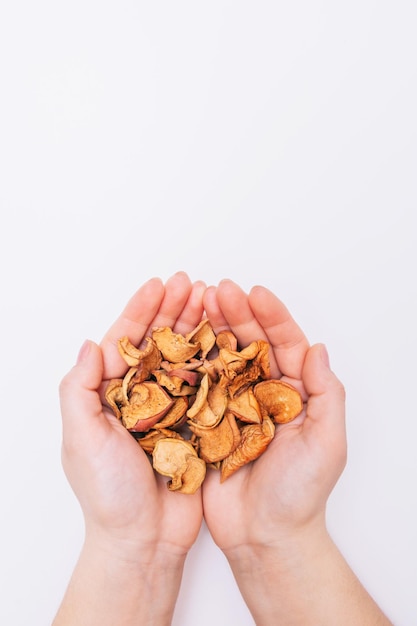 Female hands with sliced dried garden apples Dried fruits Healthy natural foods White background Closeup