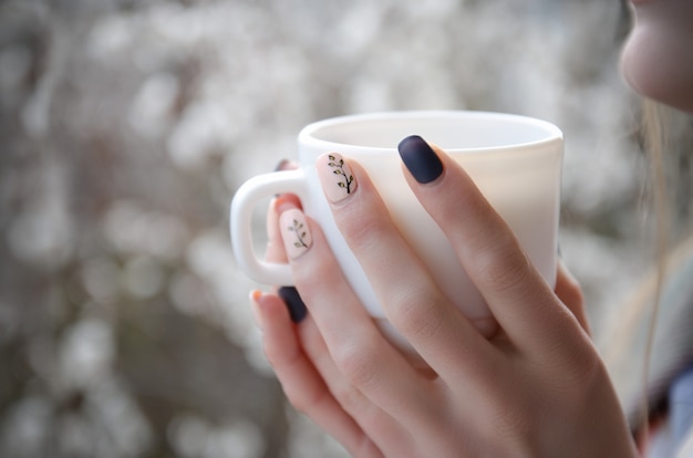 Female hands with a white mug in hands