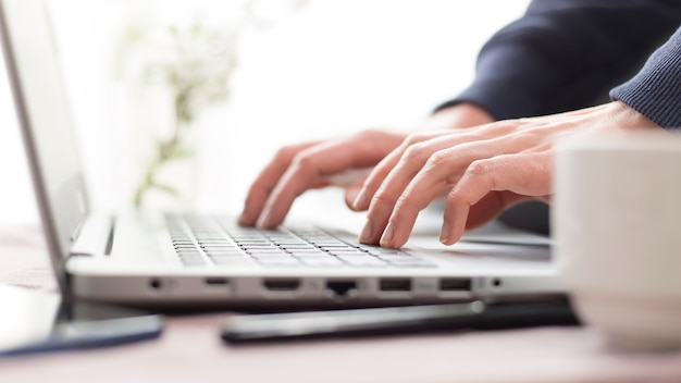 Photo female hands work on the laptop keyboard.