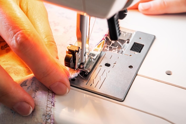 female hands work on the sewing machine closeup sewing training and hobby concept