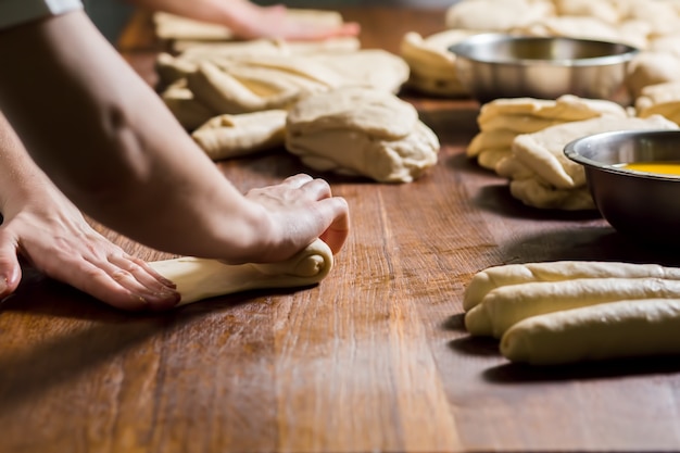 Female hands working with dough baker rolling dough