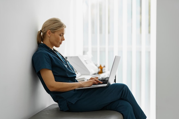 Female healthcare worker using laptop while working at doctor39s office