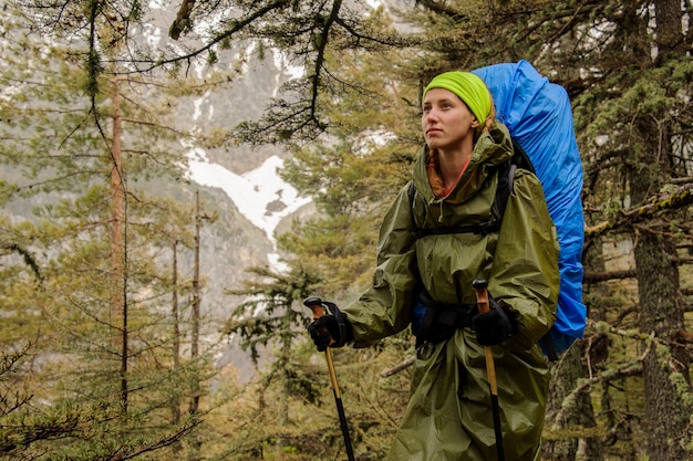 Female hiker in raincoat posing on mountain