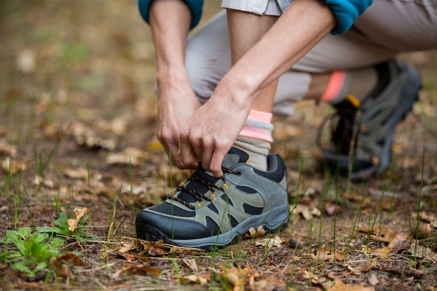 Female hiker tying shoelaces