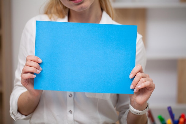 Female holding a blank sheet of paper with space for text