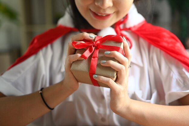 Female holding Christmas gift with Red ribbon.