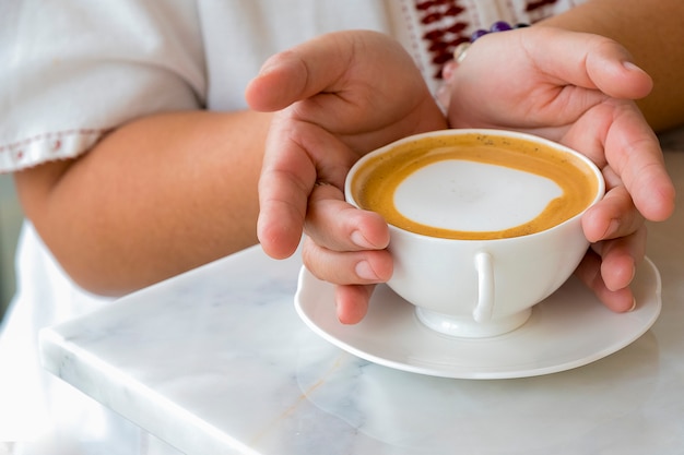 A female holding a cup of coffee 