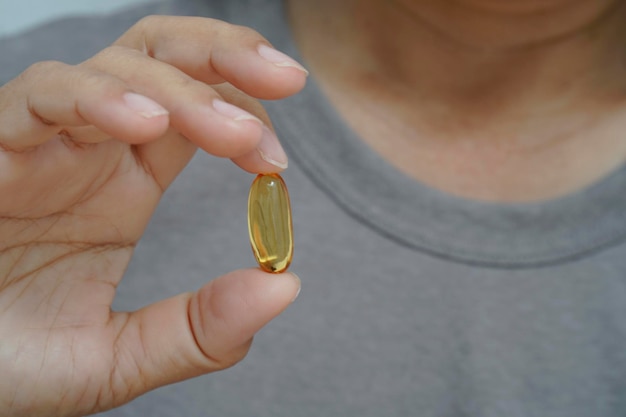 Female holding with Omega 3 fish oil capsule