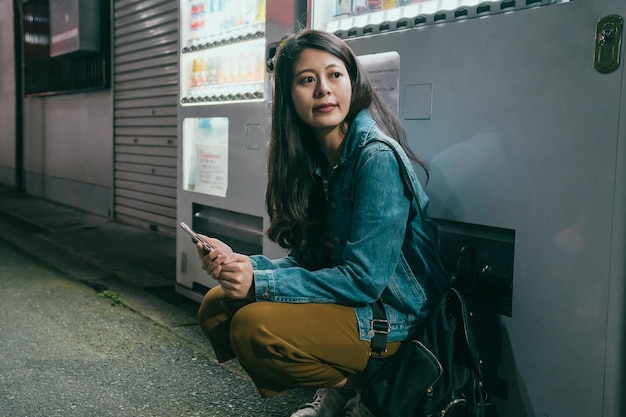 Female kneeling down rely on vending machine