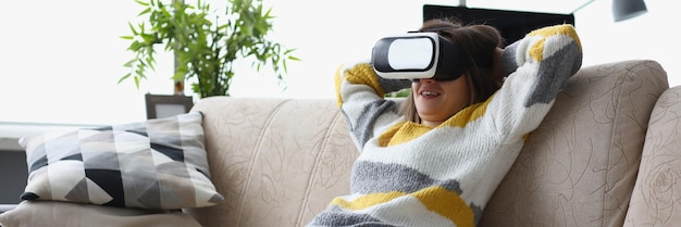 Female lay casually on couch in vr glasses use modern device at home test new development