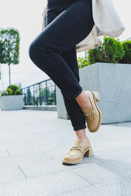 Female legs in black jeans and beige high heels Beige leather shoes closeup