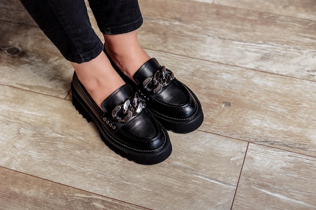 Female legs in black jeans and black laceup shoes Black leather shoes closeup