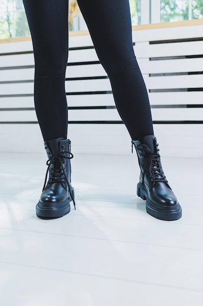 Female legs in black leather boots closeup Autumn women's boots without a heel