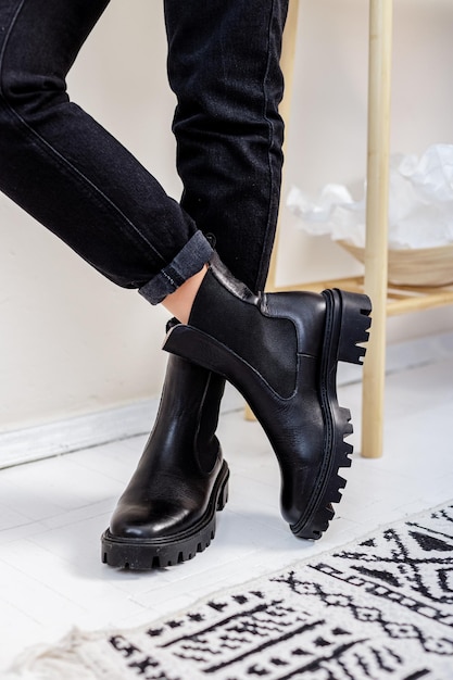 Female legs in black leather boots. New collection of winter boots for women