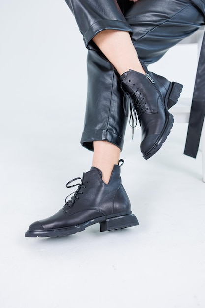 Female legs in leather pants and black leather boots Women's casual leather spring boots Stylish shoes for women