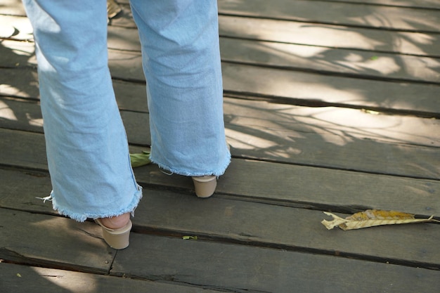 Female legs walking on wooden boardwalk