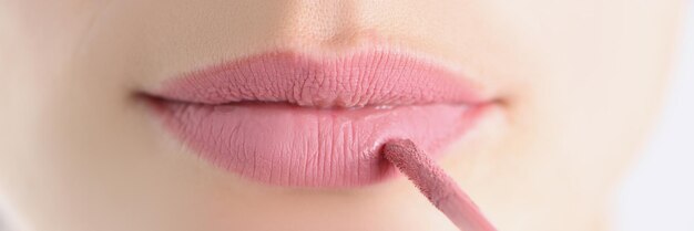 Female lips with pink lipstick and brush how to paint lips correctly concept