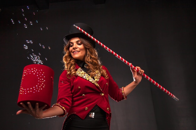 Female magician makes with soap bubbles show an illusionist