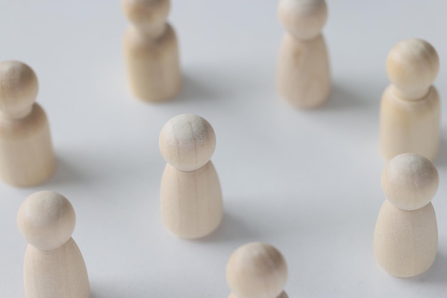 Female and male wooden figures are scattered on white background