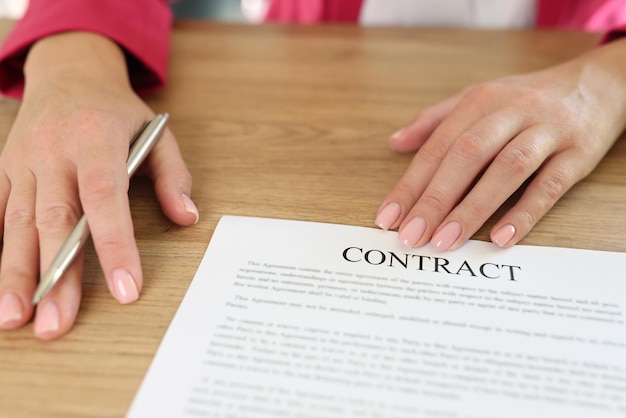 Female manager asks to sign contract while sitting at desk in office