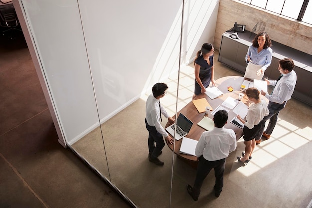 Female manager in team meeting elevated view through window