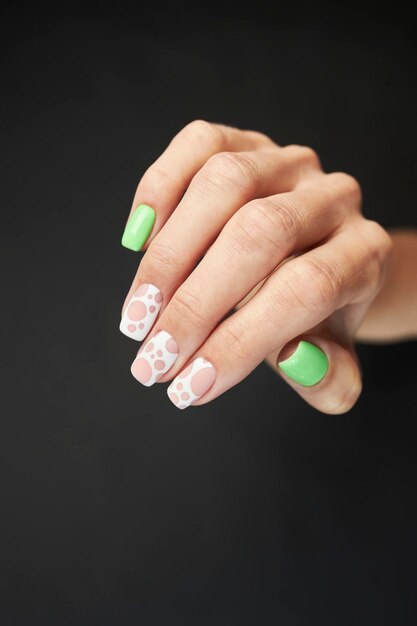 female manicure on a black background. nail. Women's hands with a manicure on a dark background.