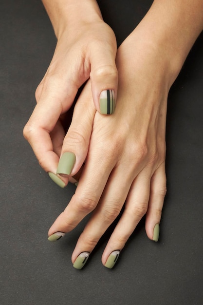 female manicure on a black background. nail. Women's hands with a manicure on a dark background.