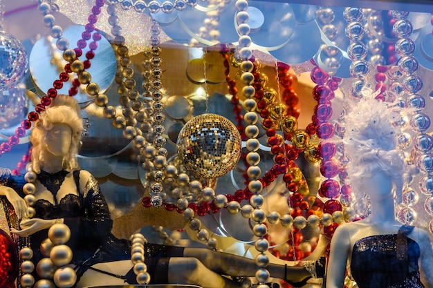 Female mannequin dressed in black lingerie and different christmas decorations in a showcase