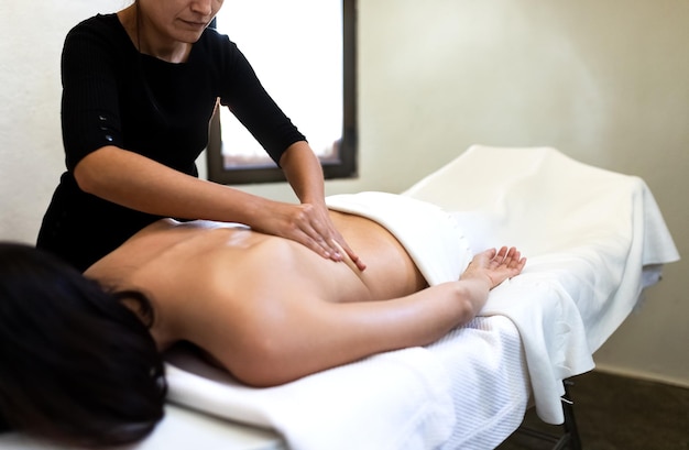 Female massage therapist giving therapeutic massage to young womanCopy space Bodycare and wellness