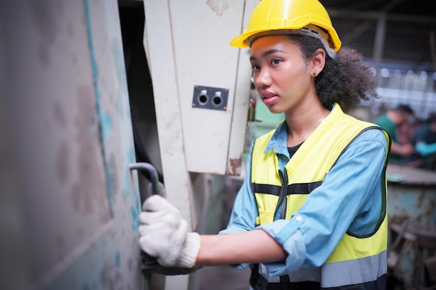 Female mechanics engineer operating lathe machine for metalwork in metal work factory