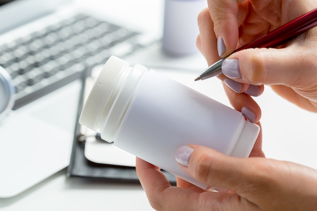 Female medicine doctor hands hold jar of pills