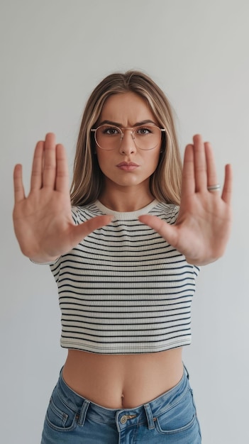 Female model doing timeout pause gesture on camera showing t shape stop symbol with arms in studio