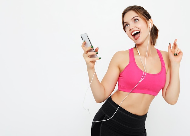 Female model wears sport clothes listens to favourite music