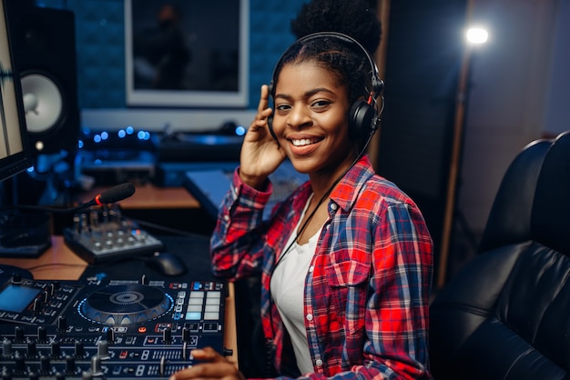 Female musician in headphones in recording studio