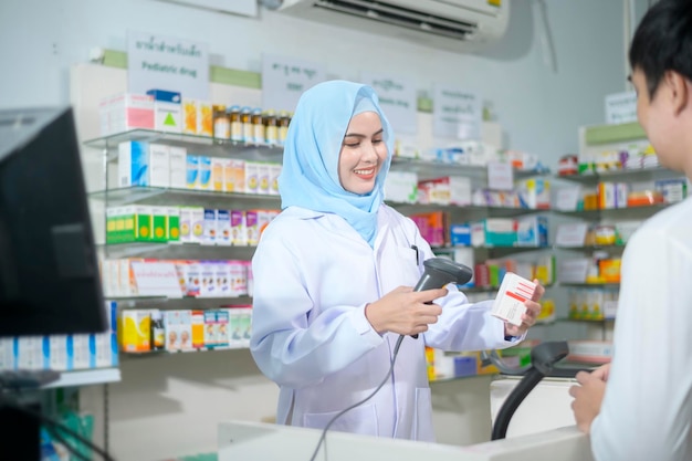 Female muslim pharmacist counseling customer about drugs usage in a modern pharmacy drugstore