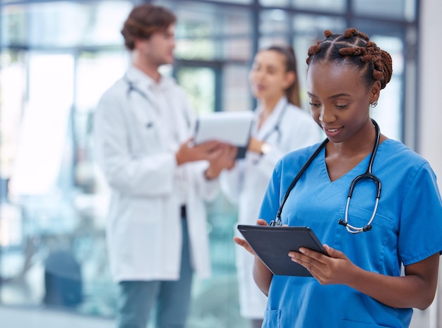 Female nurse or doctor browsing on a tablet for patient diagnosis or treatment on a medical or mobile healthcare app in a hospital Professional gp or surgeon wearing scrubs while working in a clinic