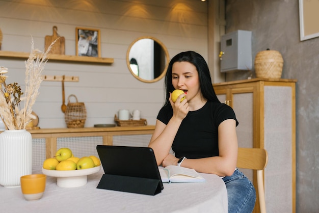 A female nutritionist or fitness trainer is sitting at her desk in front of a laptop and talking