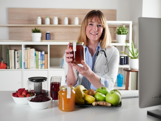 Female nutritionist holding honey in office studio