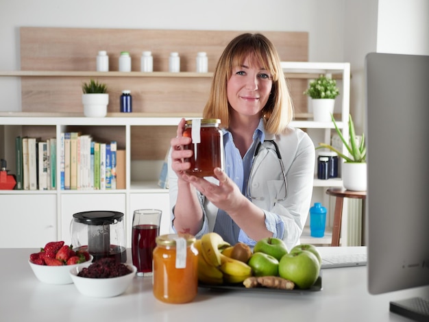 Female nutritionist holding honey in office studio