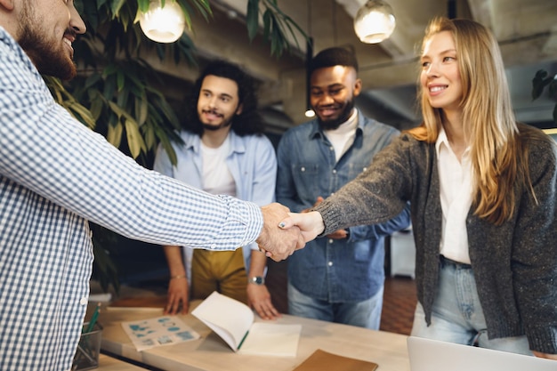 Female office executive shaking hand of new male team member employee