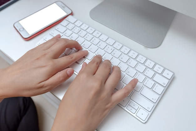 Female office worker typing on the keyboard