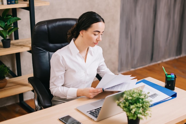 Female office worker viewing documents in workplace