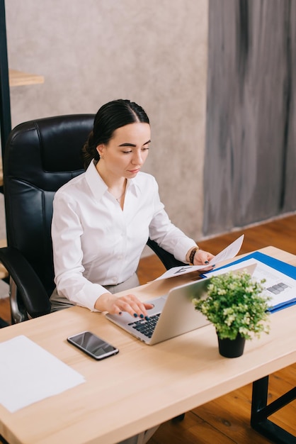 Female office worker viewing documents in workplace