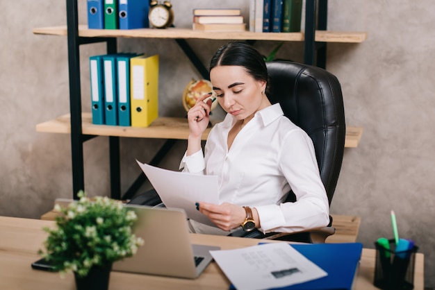 Female office worker viewing documents in workplace