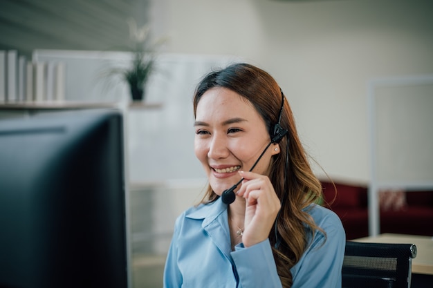 Female officer working and smiling in customer service office.