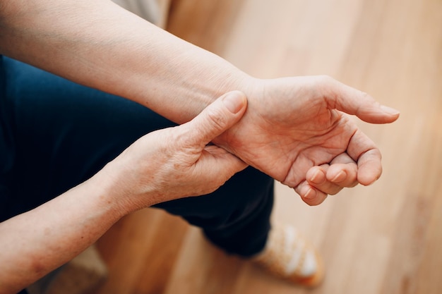 Female old hand measuring her own arm pulse Elderly woman heart health